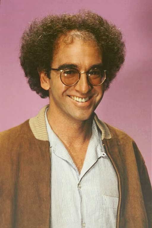  Larry David in his mid age with his curly hair wearing a spectacles