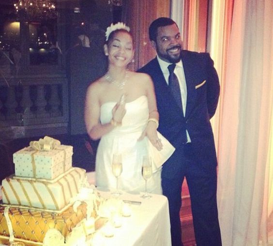 Ice Cube and her wife during their marriage. Their is cake in the background. 